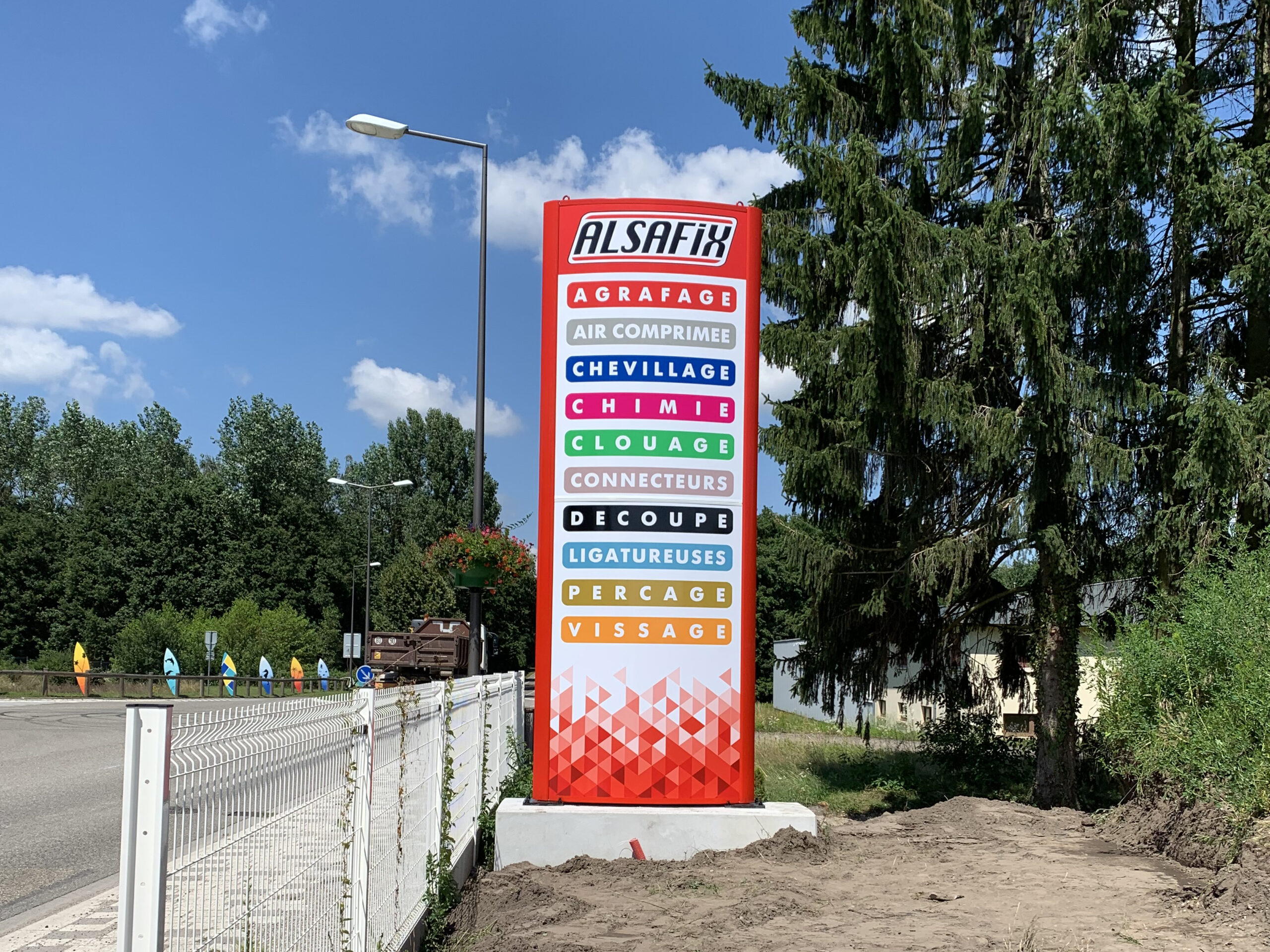 Enseigne : totem galbé en alu avec décor double et posé sur un socle en béton