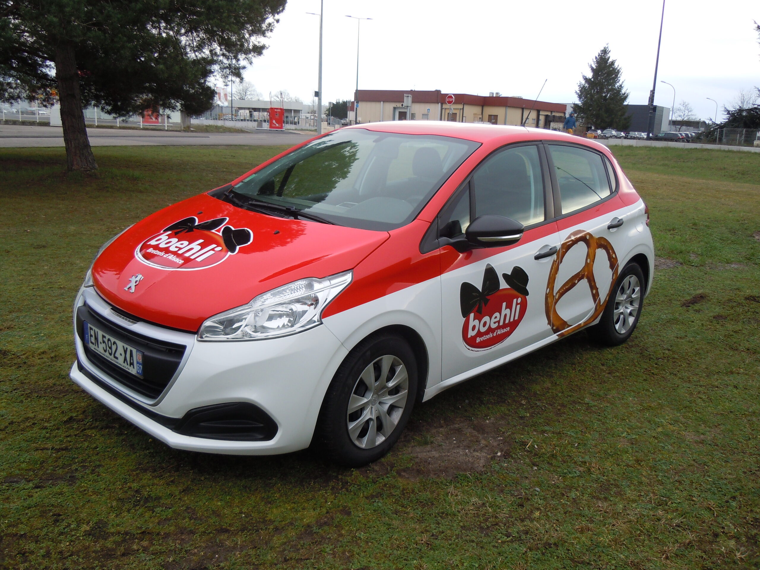 Véhicule Berline : semi covering sur une Peugeot 208 avec le toit en film teinté masse rouge et le logo et la bretzel en impression numérique