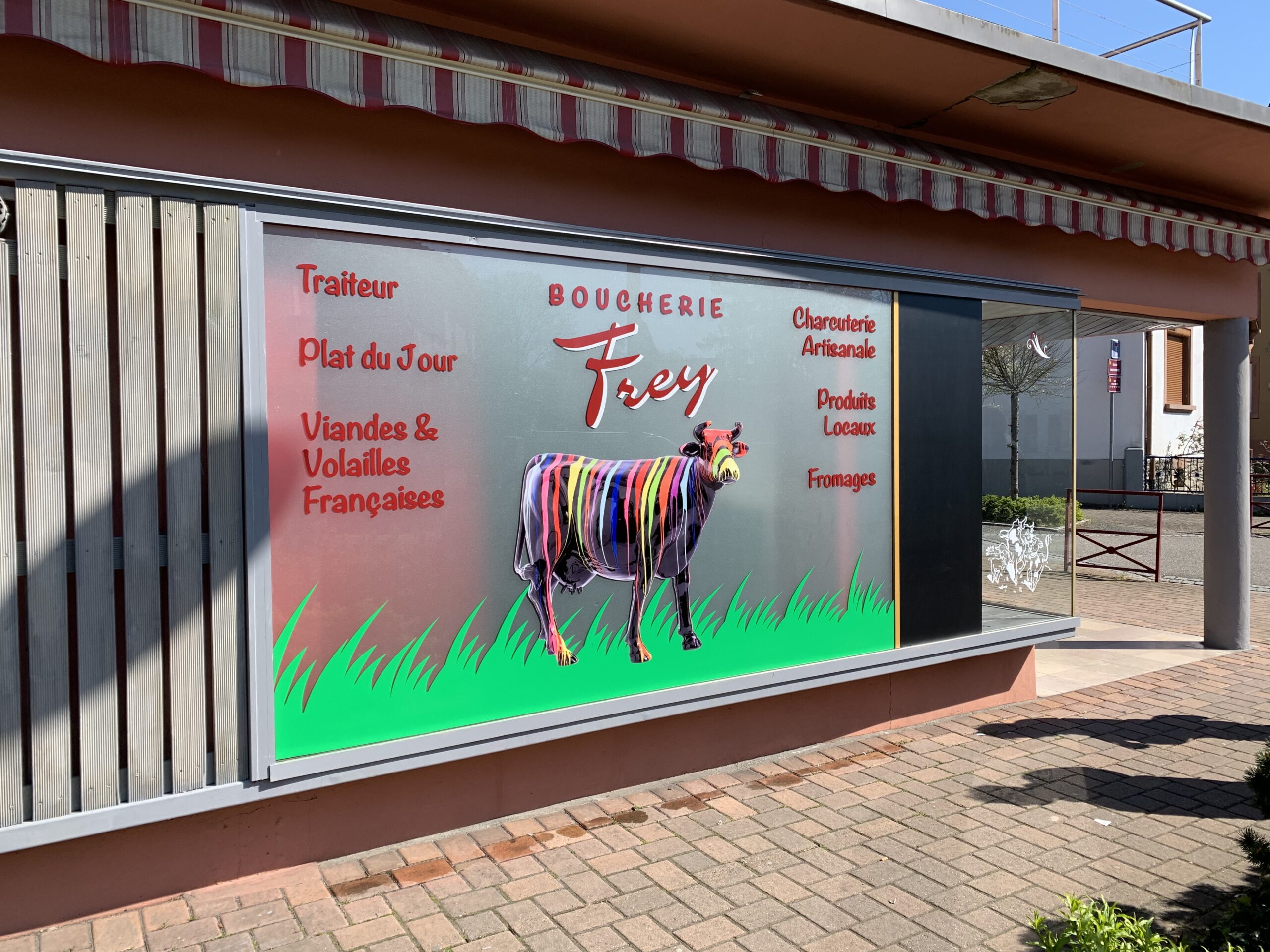 Signalétique extérieure : Décoration publicitaire d'une vitrine comprenant une photo en impression, du texte en adhésif et un film dépoli