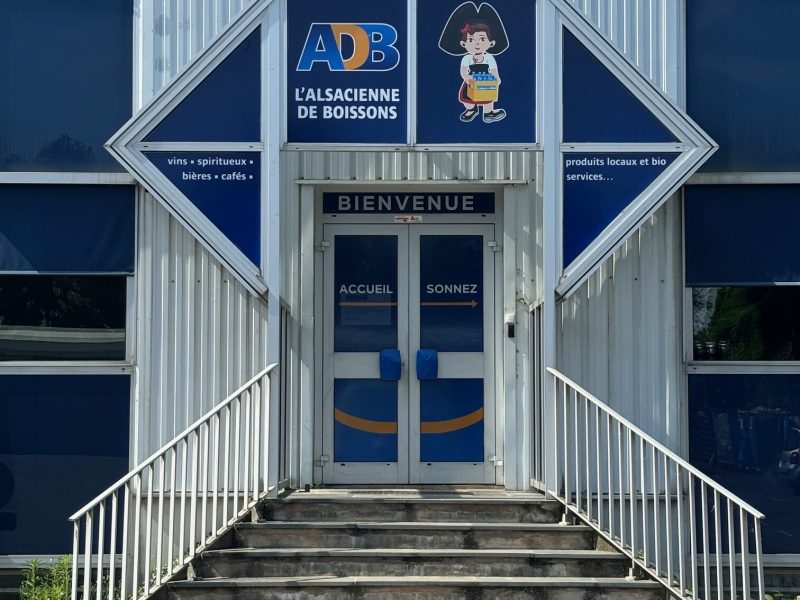 Impression des logos sur film microperforé avec collage sur les vitres de l'entrée d'un magasin